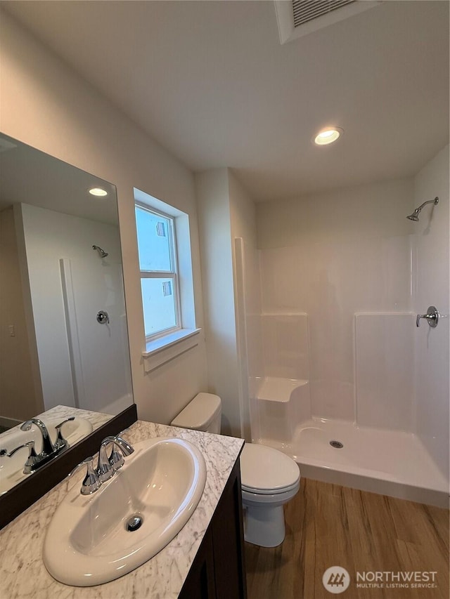 full bathroom featuring a shower, visible vents, toilet, and vanity