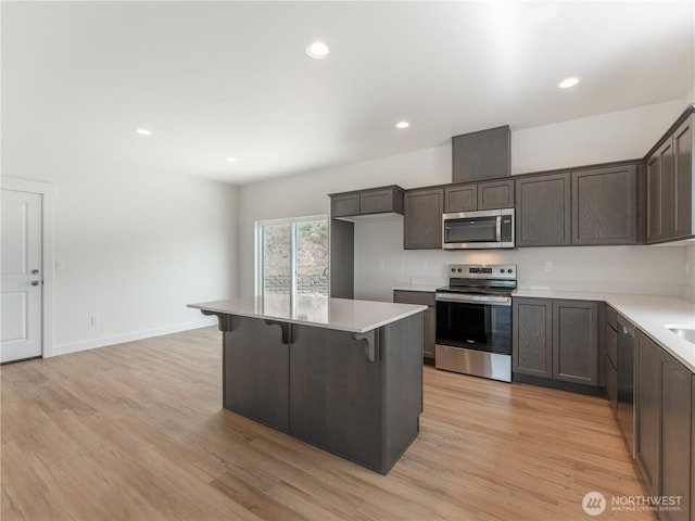 859 N Lyle Ave, East Wenatchee, WA 98802 - kitchen featuring stainless steel appliances, a kitchen bar, dark brown cabinetry, light countertops, and recessed lighting