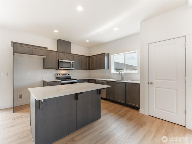 859 N Lyle Ave, East Wenatchee, WA 98802 - kitchen with stainless steel appliances, a center island, light countertops, dark brown cabinets, and light wood-style floors