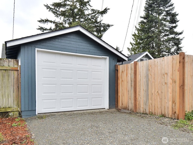 detached garage with driveway and fence