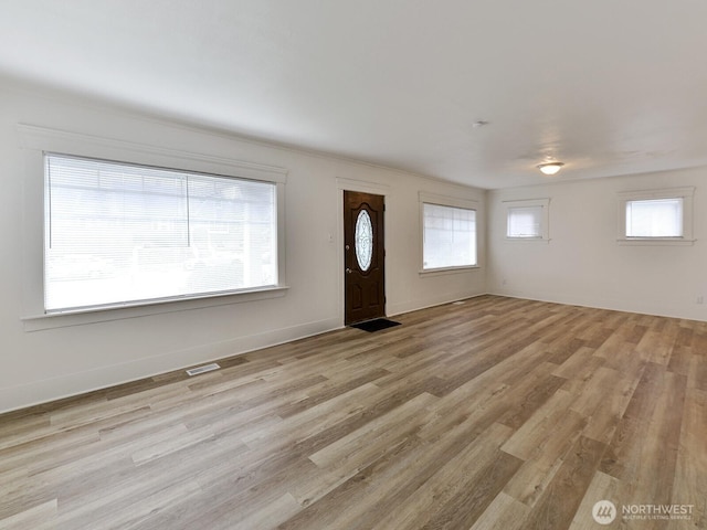 interior space with visible vents, baseboards, and wood finished floors