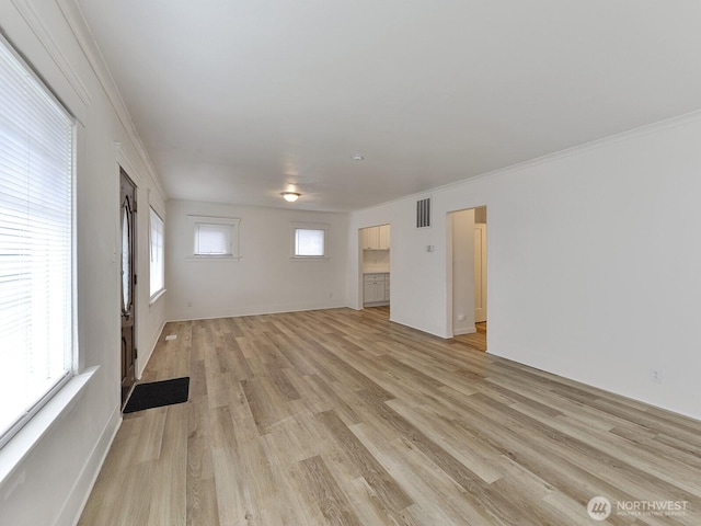 unfurnished room with visible vents, light wood-style flooring, and a healthy amount of sunlight