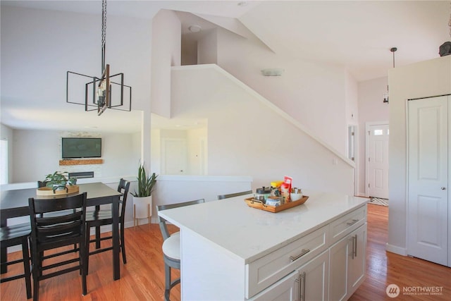 kitchen featuring a kitchen island, light wood-style floors, hanging light fixtures, and light countertops