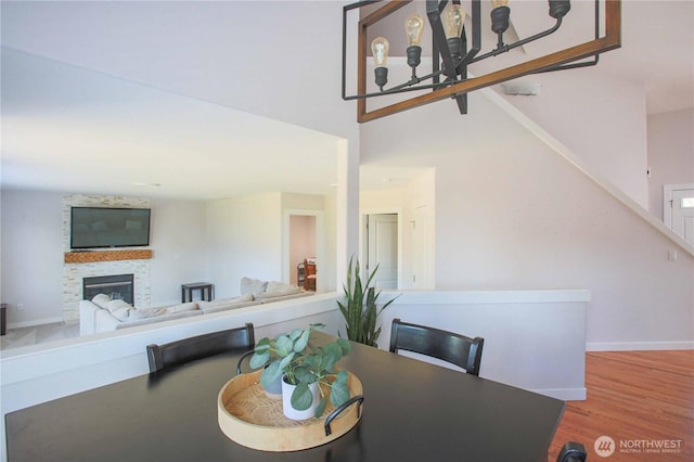 dining room with a glass covered fireplace, baseboards, and wood finished floors