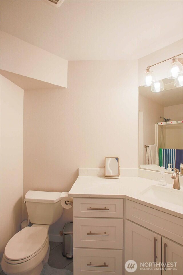 bathroom with tile patterned flooring, toilet, and vanity