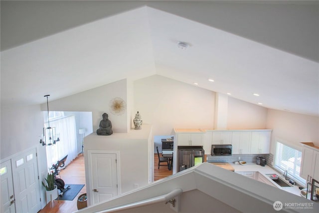 interior space featuring recessed lighting, a sink, stainless steel appliances, light wood-style floors, and white cabinetry