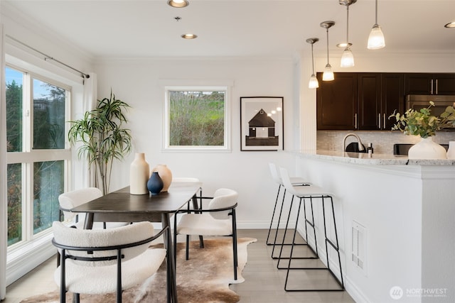 dining room with recessed lighting, a wealth of natural light, and ornamental molding