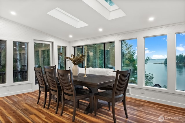 sunroom / solarium with lofted ceiling with skylight and a water view