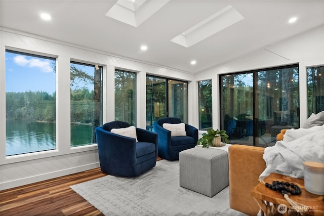 sunroom featuring lofted ceiling with skylight and a healthy amount of sunlight