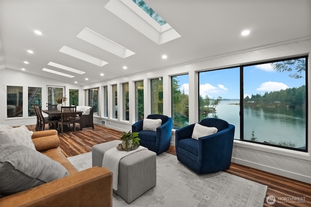 living area with recessed lighting, vaulted ceiling with skylight, and wood finished floors