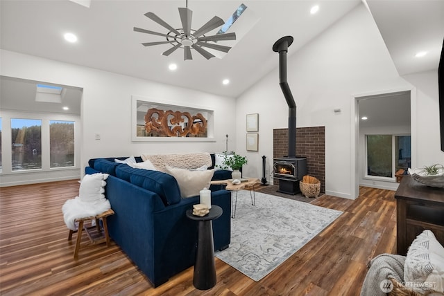 living area featuring a wood stove, recessed lighting, wood finished floors, and ceiling fan