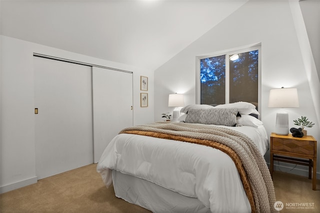 bedroom with a closet, light colored carpet, and vaulted ceiling