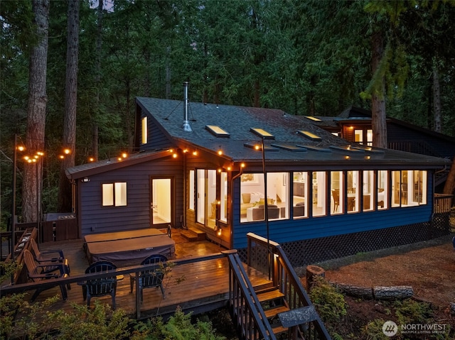 back of house with a wooden deck and a sunroom