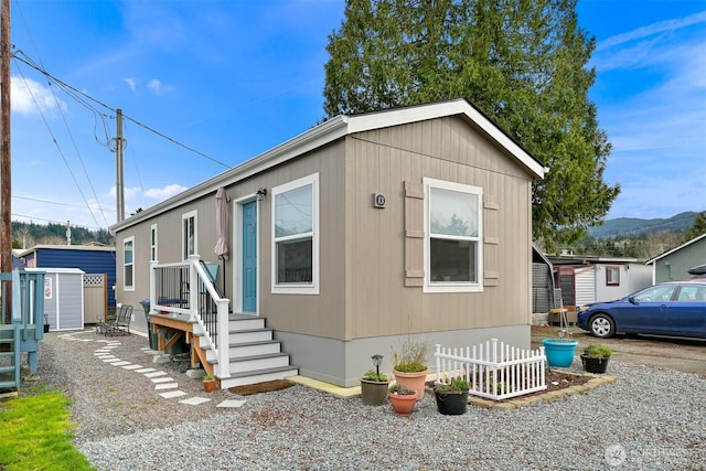 view of front of home with a storage shed, fence, and an outdoor structure