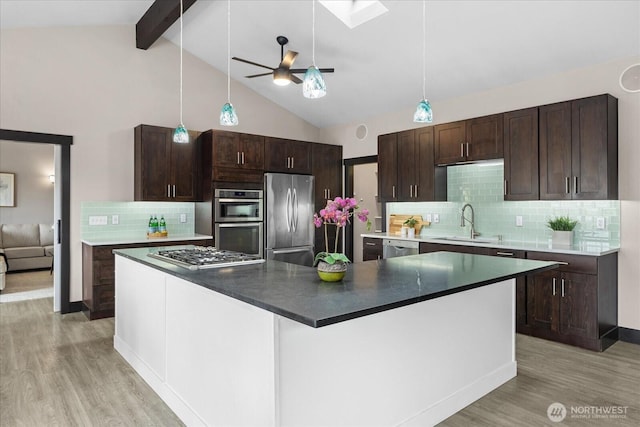 kitchen with stainless steel appliances, a ceiling fan, light wood-style floors, and a sink