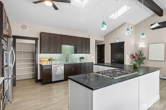 kitchen with ceiling fan, light wood-type flooring, appliances with stainless steel finishes, and a skylight