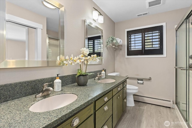 full bathroom with visible vents, a baseboard heating unit, and a sink