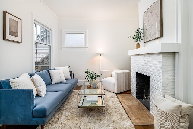 living area with baseboards, a brick fireplace, wood finished floors, and crown molding