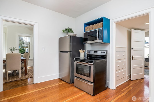 kitchen with stainless steel appliances, light wood-type flooring, and baseboards