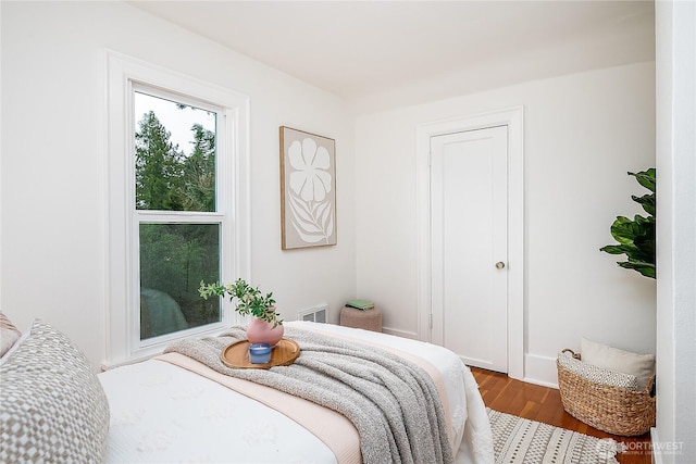 bedroom featuring visible vents and wood finished floors