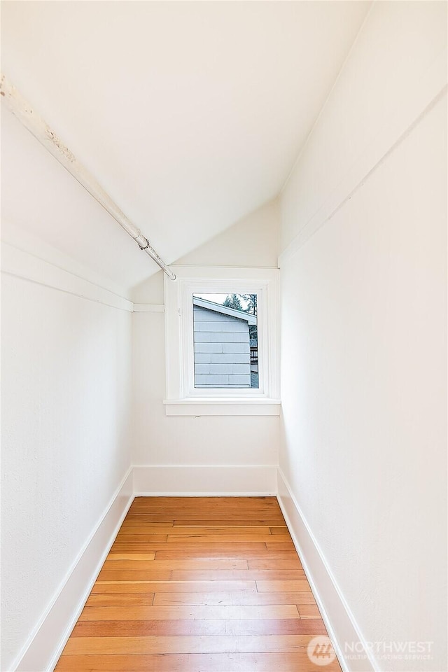 spacious closet with light wood-type flooring and vaulted ceiling