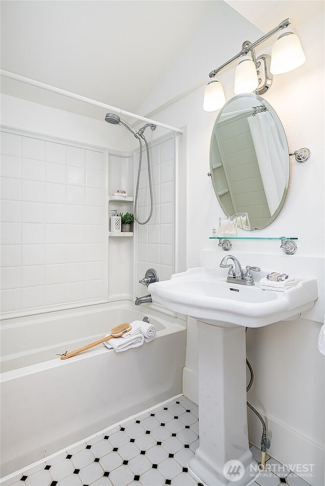 full bath with tile patterned floors, shower / bath combo with shower curtain, and vaulted ceiling