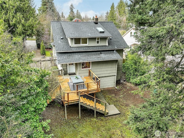 rear view of property with a deck, stairway, a chimney, and roof with shingles