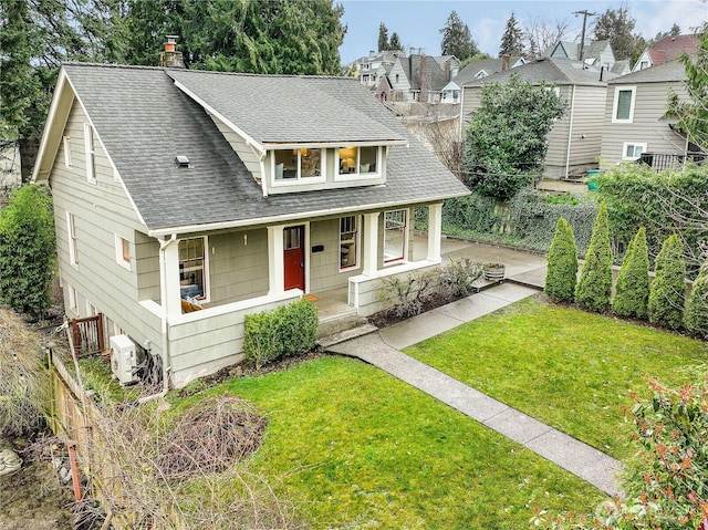 view of front of house with ac unit, covered porch, roof with shingles, a front yard, and a chimney