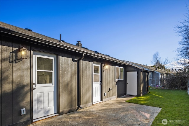 rear view of property featuring a yard, fence, a chimney, and a patio area