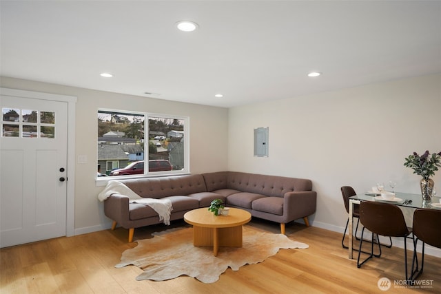 living area with electric panel, light wood-style floors, recessed lighting, and baseboards