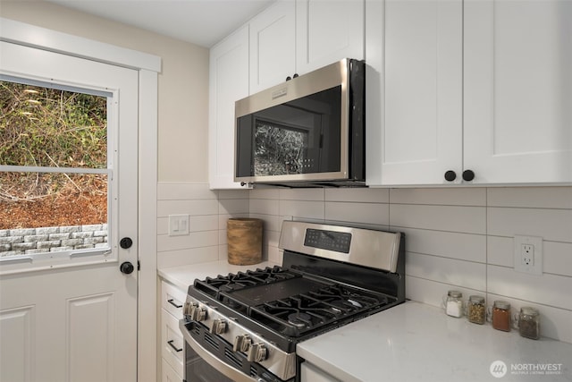 kitchen featuring white cabinetry, light countertops, backsplash, and stainless steel appliances