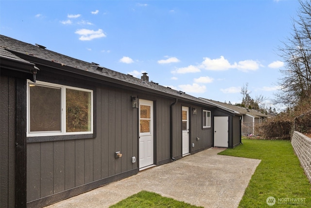 rear view of property featuring a lawn, a chimney, a patio, and fence