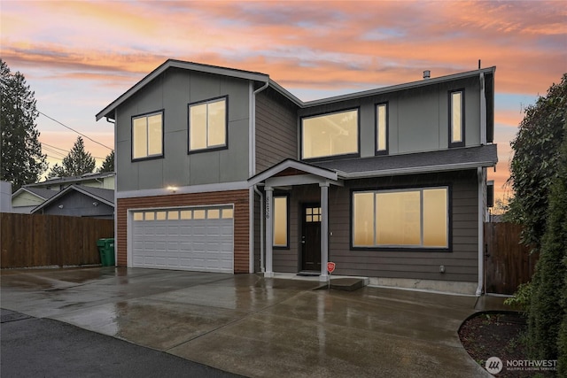 view of front of home with a garage, driveway, and fence