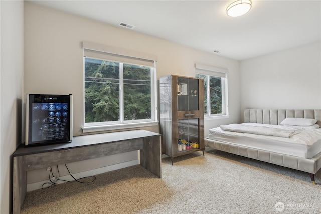 carpeted bedroom featuring visible vents