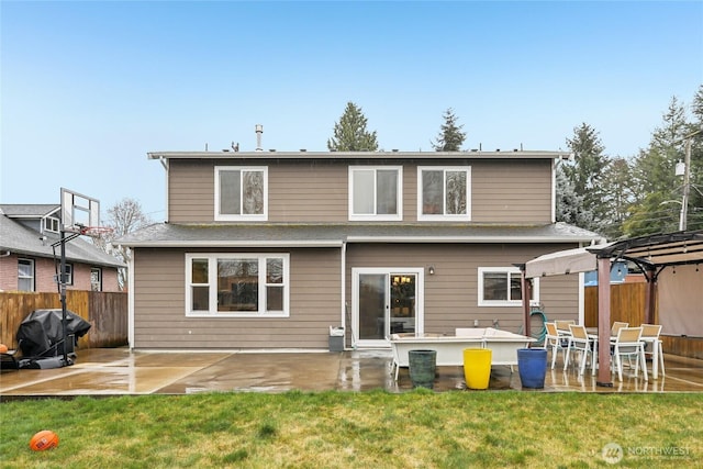 rear view of property featuring a patio, a yard, and fence