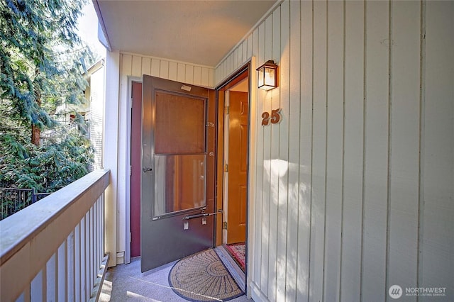 view of exterior entry with a balcony