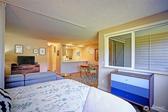 bedroom with a textured ceiling and baseboards