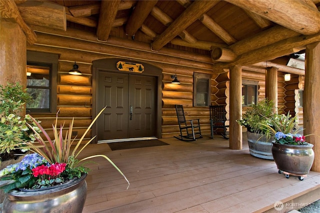 entrance to property with covered porch and log exterior