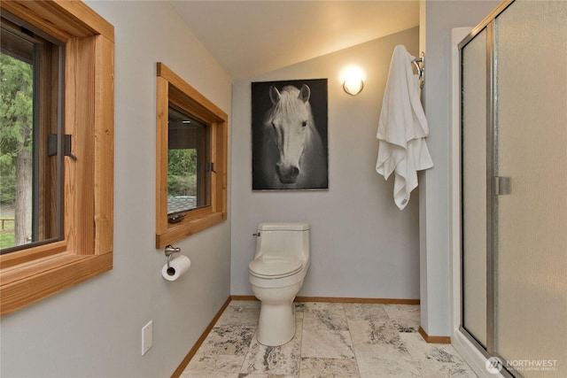 bathroom featuring baseboards, toilet, lofted ceiling, and a shower stall