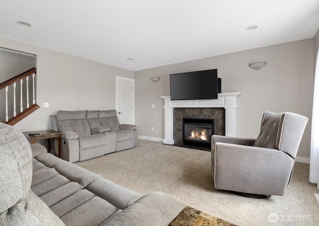 living room with stairway, a fireplace, baseboards, and carpet