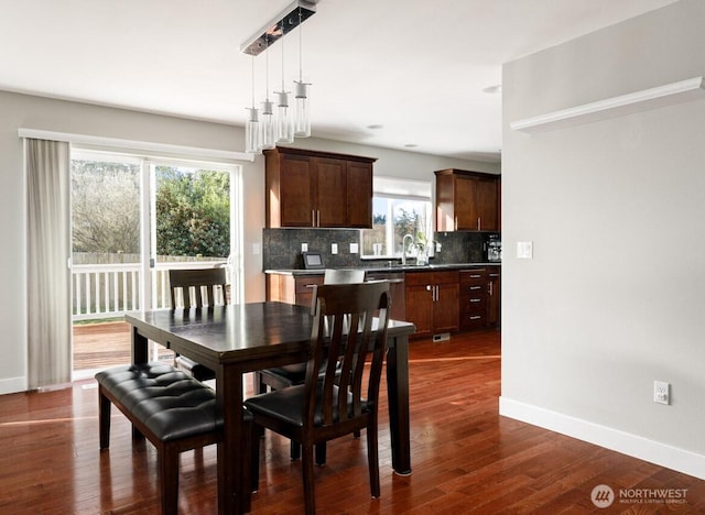 dining space featuring baseboards and dark wood-style floors