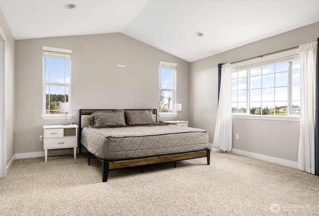 bedroom featuring baseboards, multiple windows, lofted ceiling, and light carpet