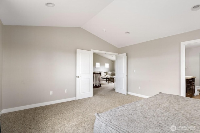 unfurnished bedroom featuring baseboards, lofted ceiling, and light carpet