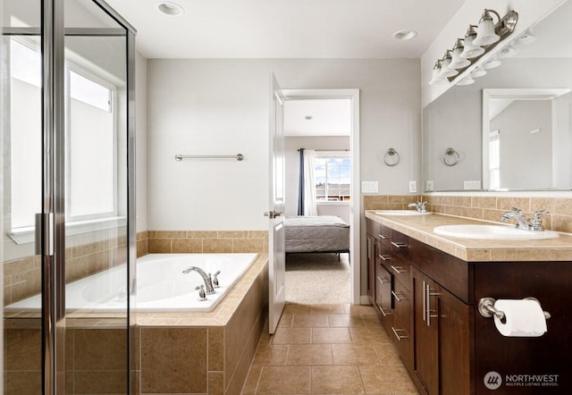 full bath featuring tile patterned flooring, double vanity, a bath, ensuite bath, and a sink