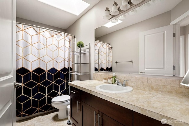 full bathroom with vanity, a skylight, toilet, and a shower with curtain