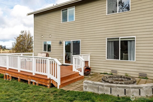 back of house featuring a fire pit and a deck