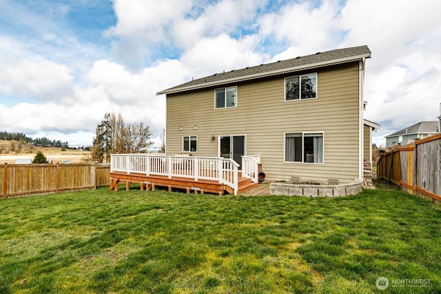 rear view of house featuring a yard, a fenced backyard, and a wooden deck