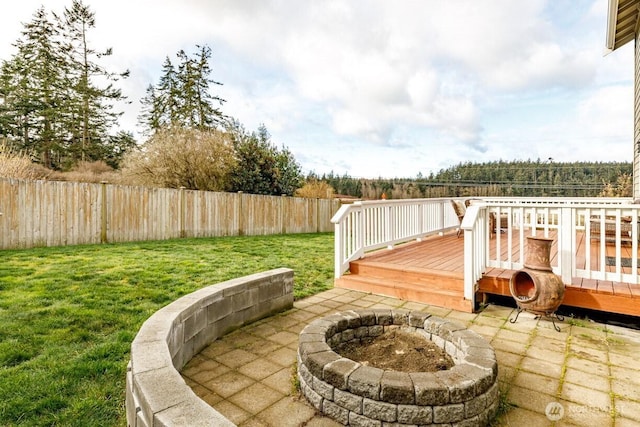 view of patio / terrace with a deck, a fire pit, and a fenced backyard