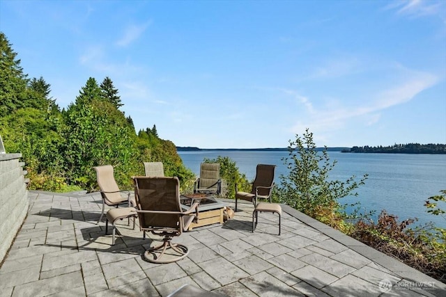 view of patio / terrace with a water view and an outdoor fire pit