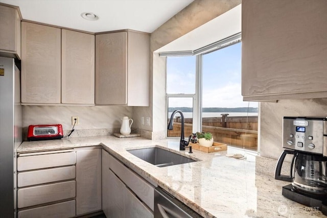 kitchen featuring gray cabinets, a sink, appliances with stainless steel finishes, a toaster, and light stone countertops